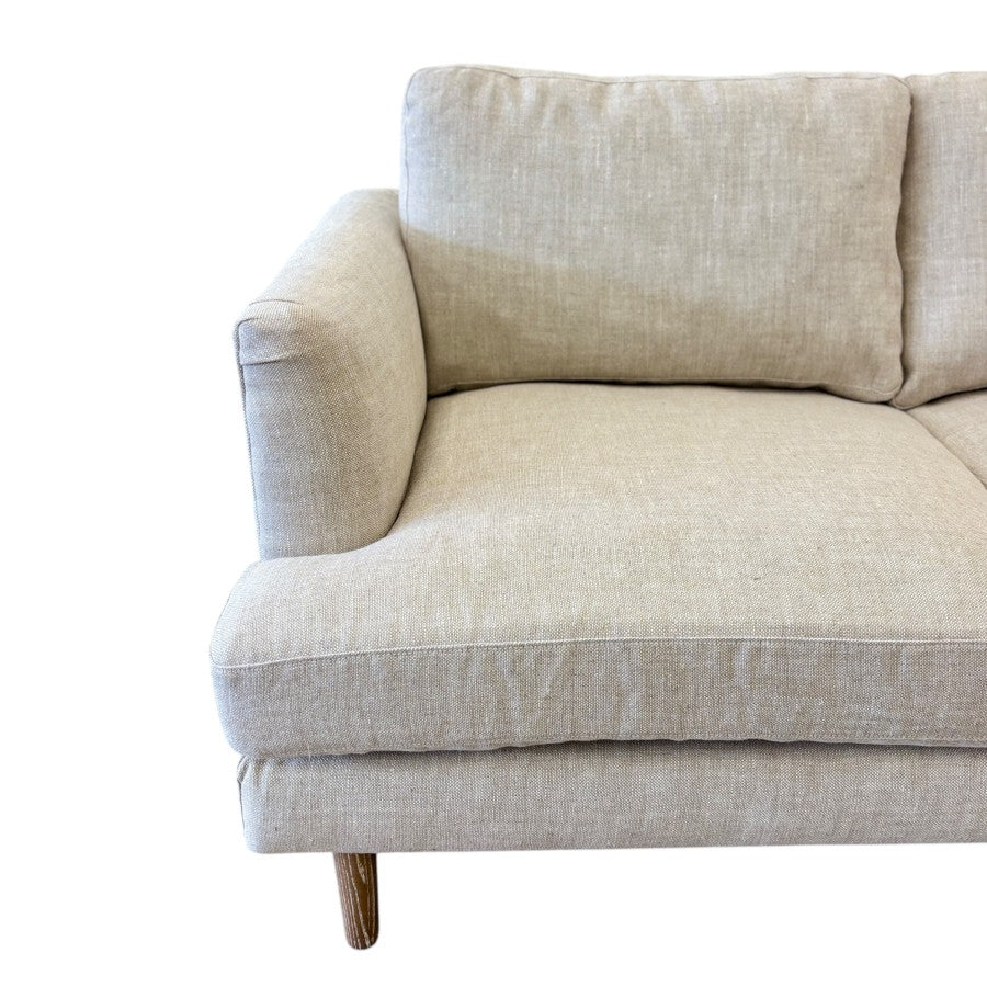 Close-up of the Thomas Sofa's solid timber leg, highlighting the natural timber finish and quality craftsmanship.