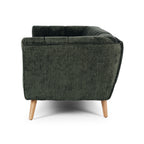 Side profile of the Towelie Sofa in Fern Green, highlighting its low profile, curved silhouette and channel-tufted upholstery.
