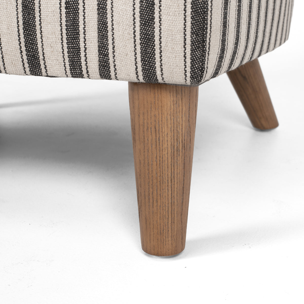 Close-up of Tyler Tub Chair timber leg and textured striped upholstery