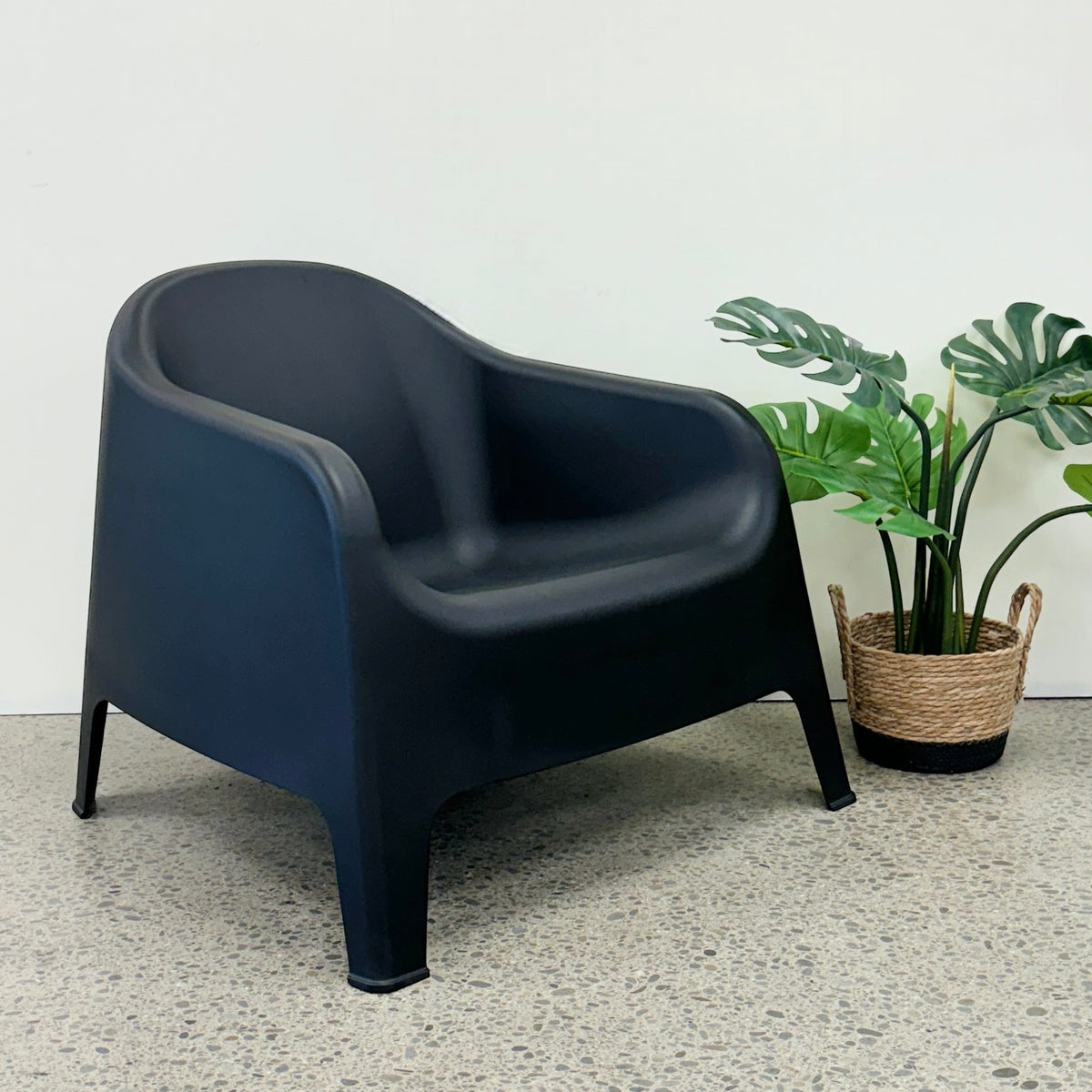Wainui Outdoor Chair in Black styled with potted greenery