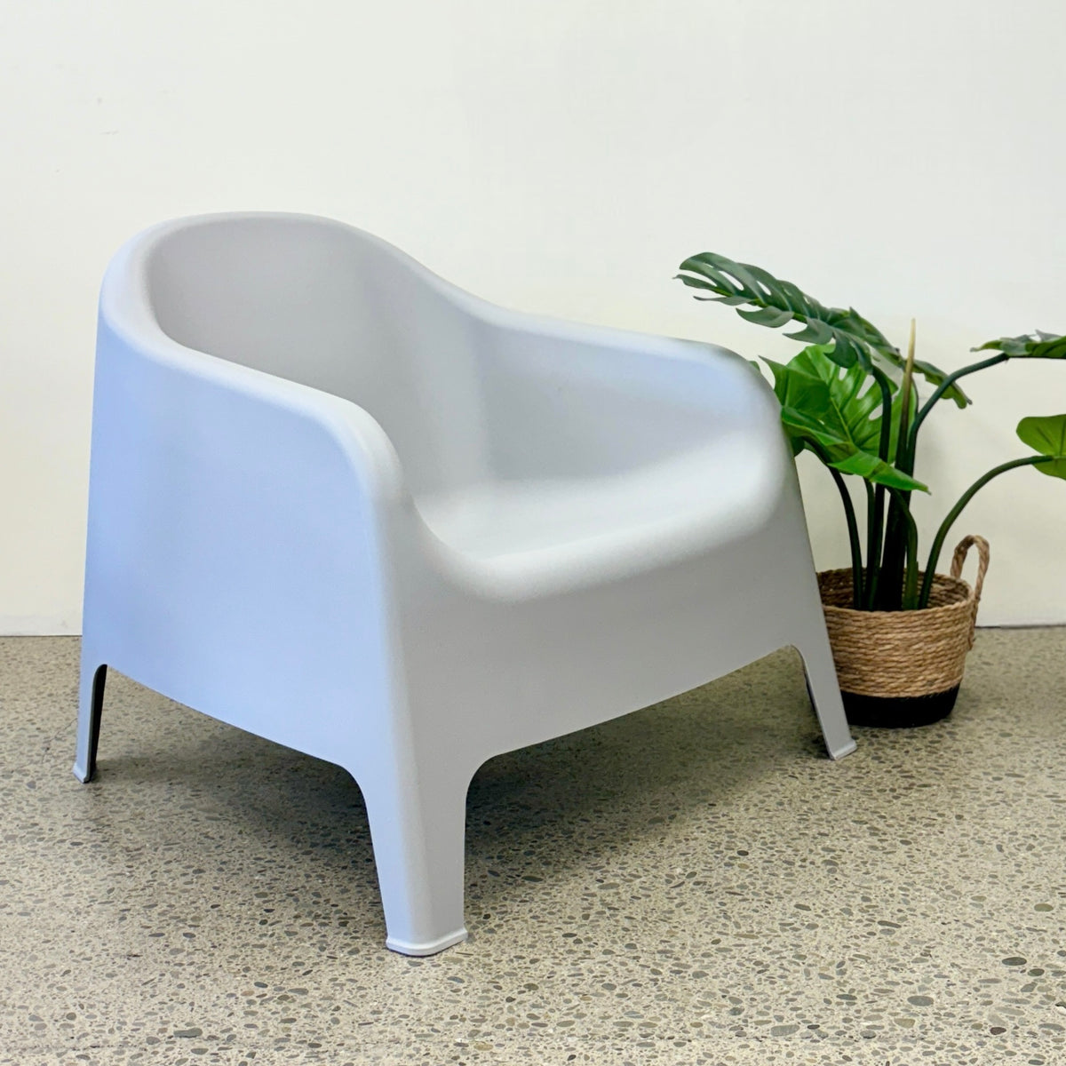 Wainui Outdoor Chair in Grey styled with potted greenery