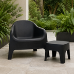 Wainui black outdoor side table styled with matching Wainui chair in a leafy outdoor setting