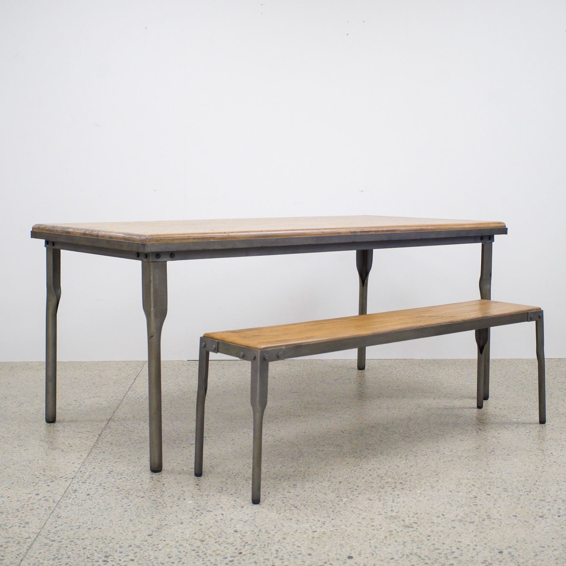 The Workman Dining Table paired with a matching timber bench, creating a relaxed and practical dining setting.
